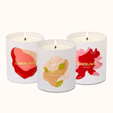 Three scented candles with colorful labels on a white background