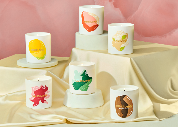 Set of candles with colorful designs on a beige surface and pink background