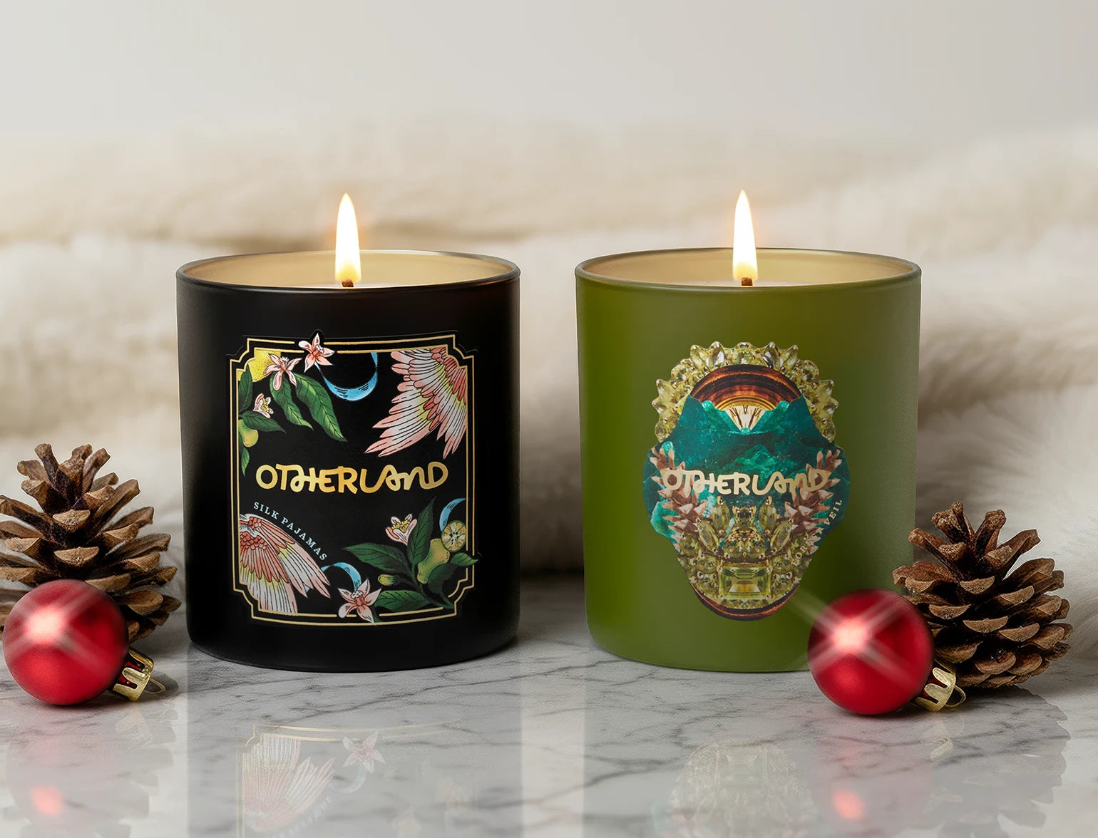 Two lit candles with decorative labels on a marble surface with festive decorations.