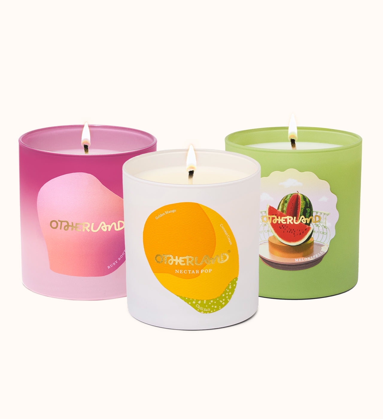 Three candles with colorful labels and 'Otherland' branding on a white background