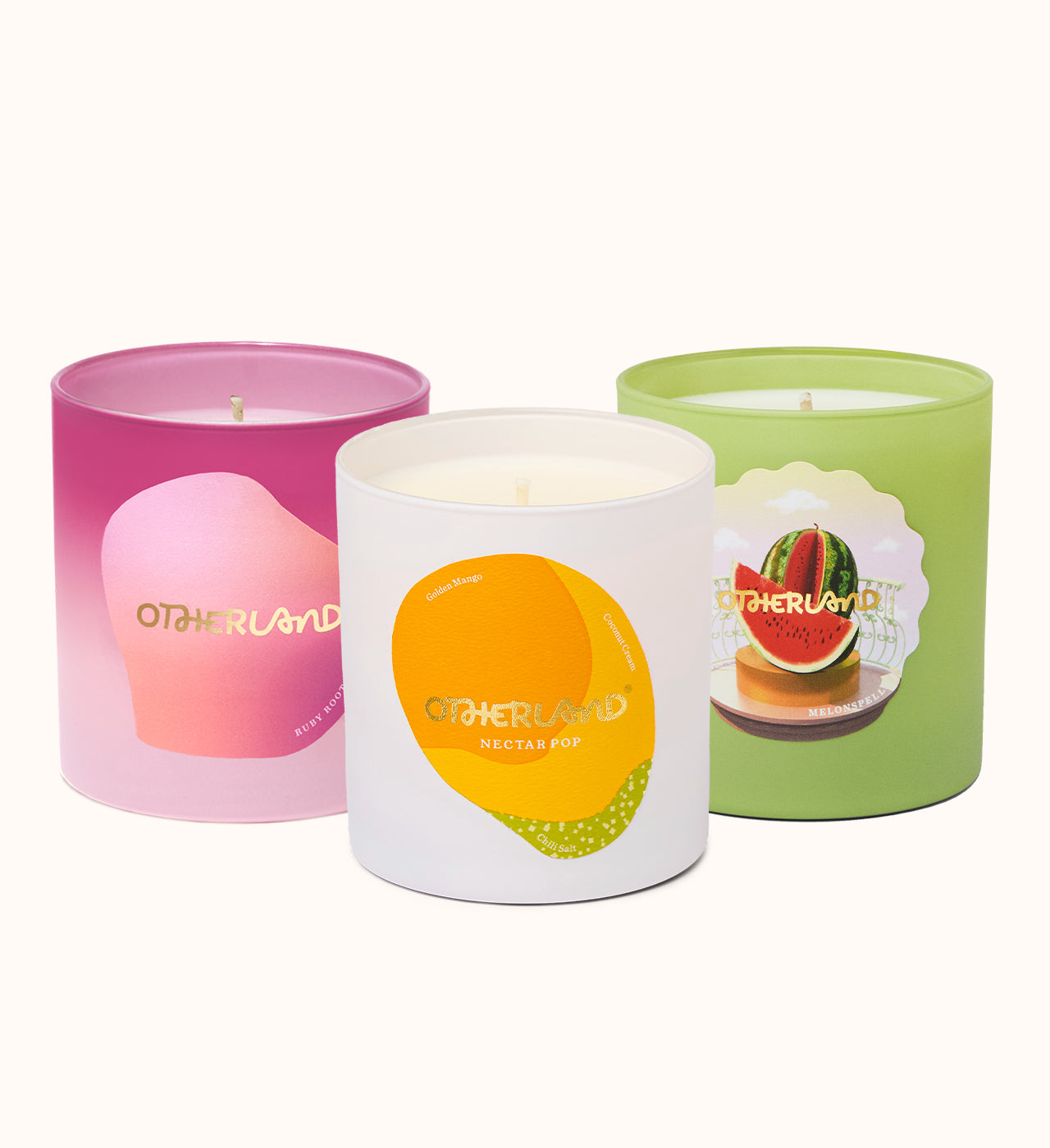 Three candles from Otherland with colorful labels on a white background