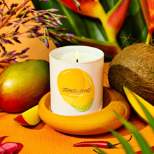 Candle with 'Otherland' branding surrounded by tropical fruits and plants on a warm-toned background