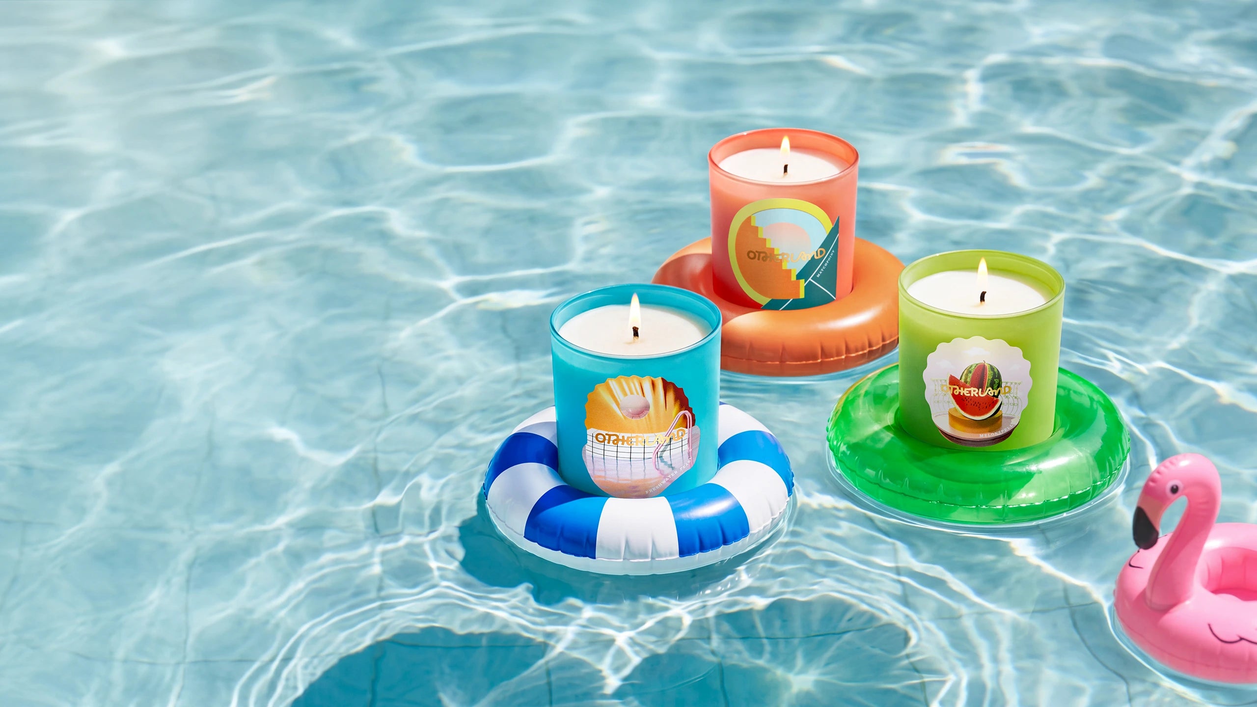 Colorful candles with cartoon designs on inflatable rings floating in water.