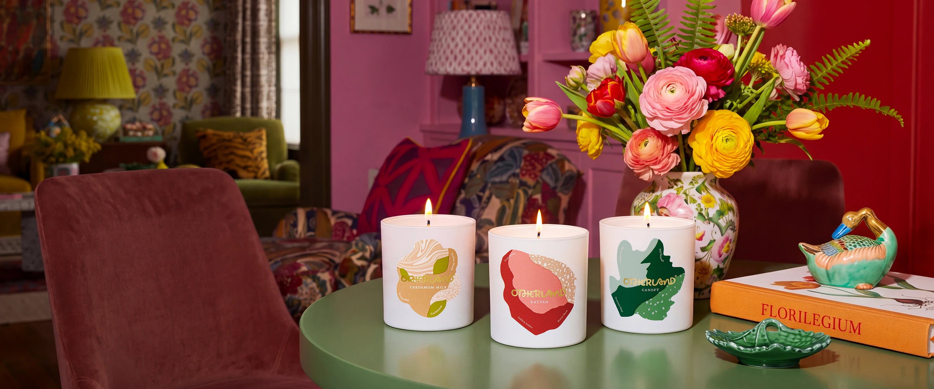 Decorative candles with floral designs on a table in a cozy room.