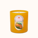 Yellow candle with a label featuring an orange on a white background