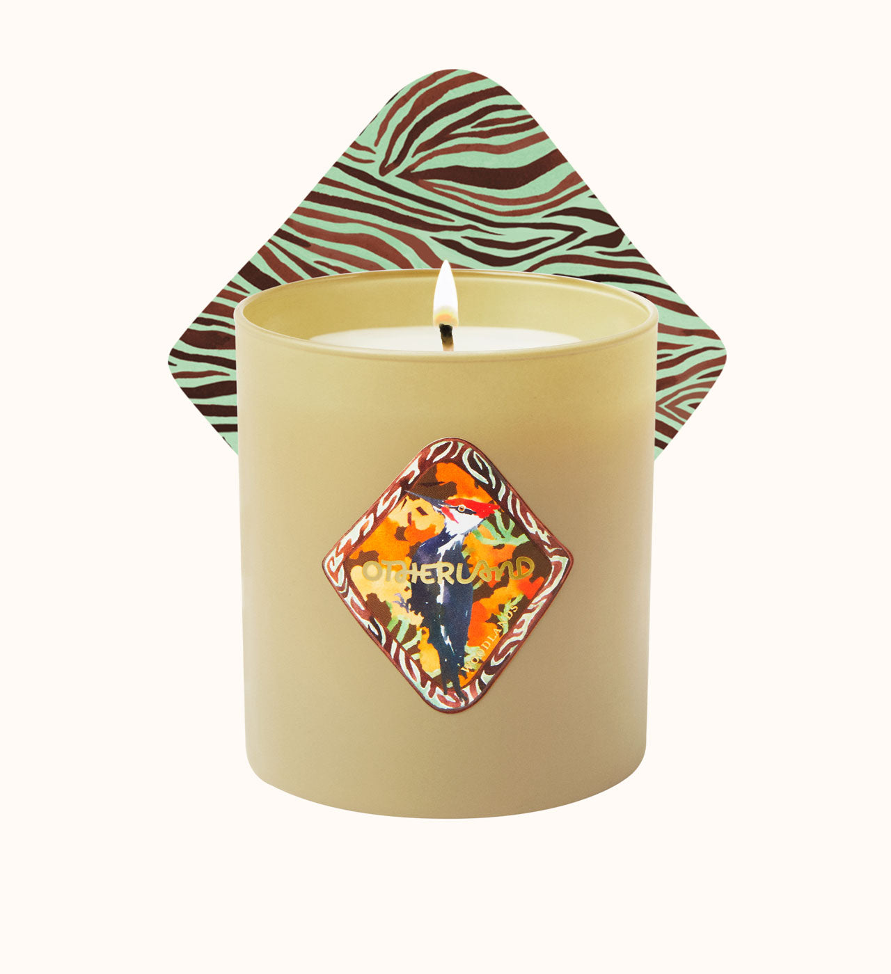 Candle with a decorative label and zebra-patterned lid on a white background