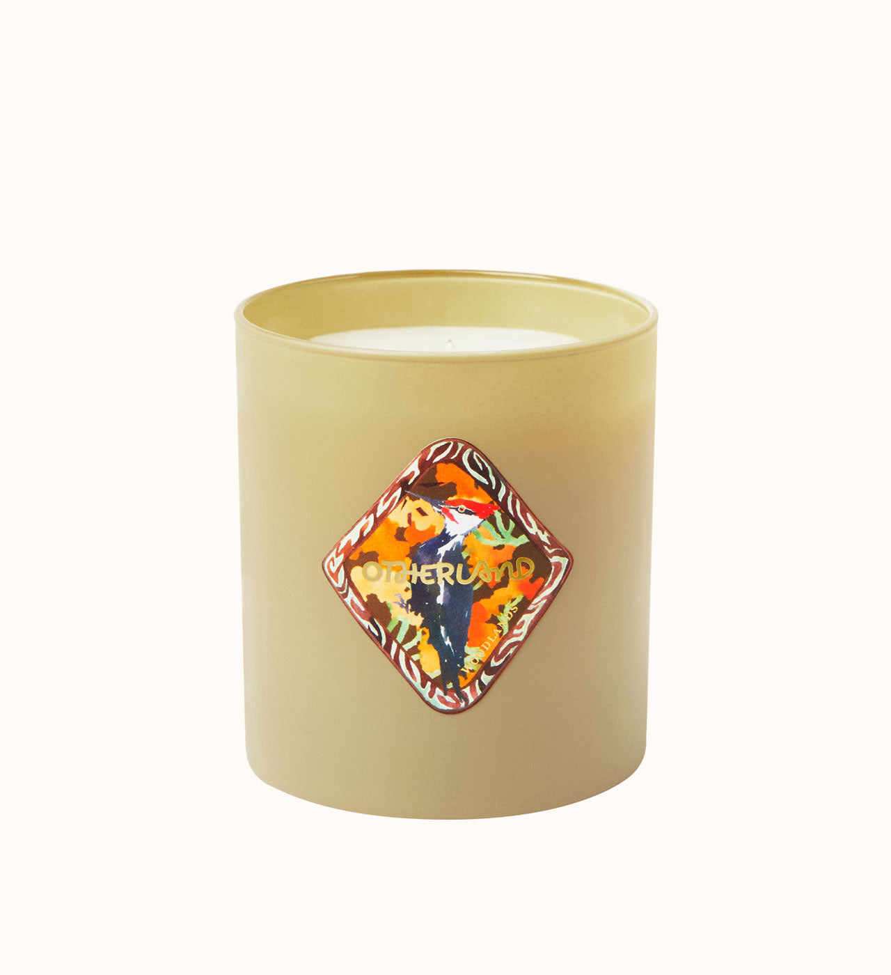 Beige candle with a decorative label on a white background
