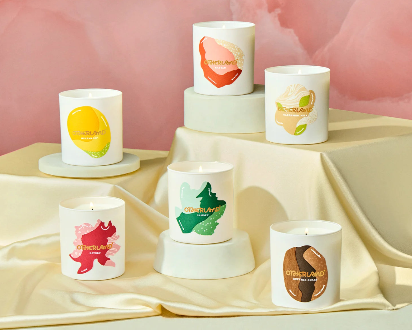 Set of candles with colorful designs on a light fabric background