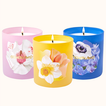 Three colorful candles with floral designs on a white background