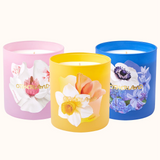 Three colorful candles with floral designs on a white background