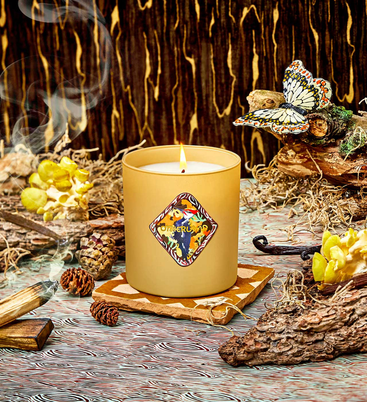 Candle with decorative label on a wooden surface with natural elements
